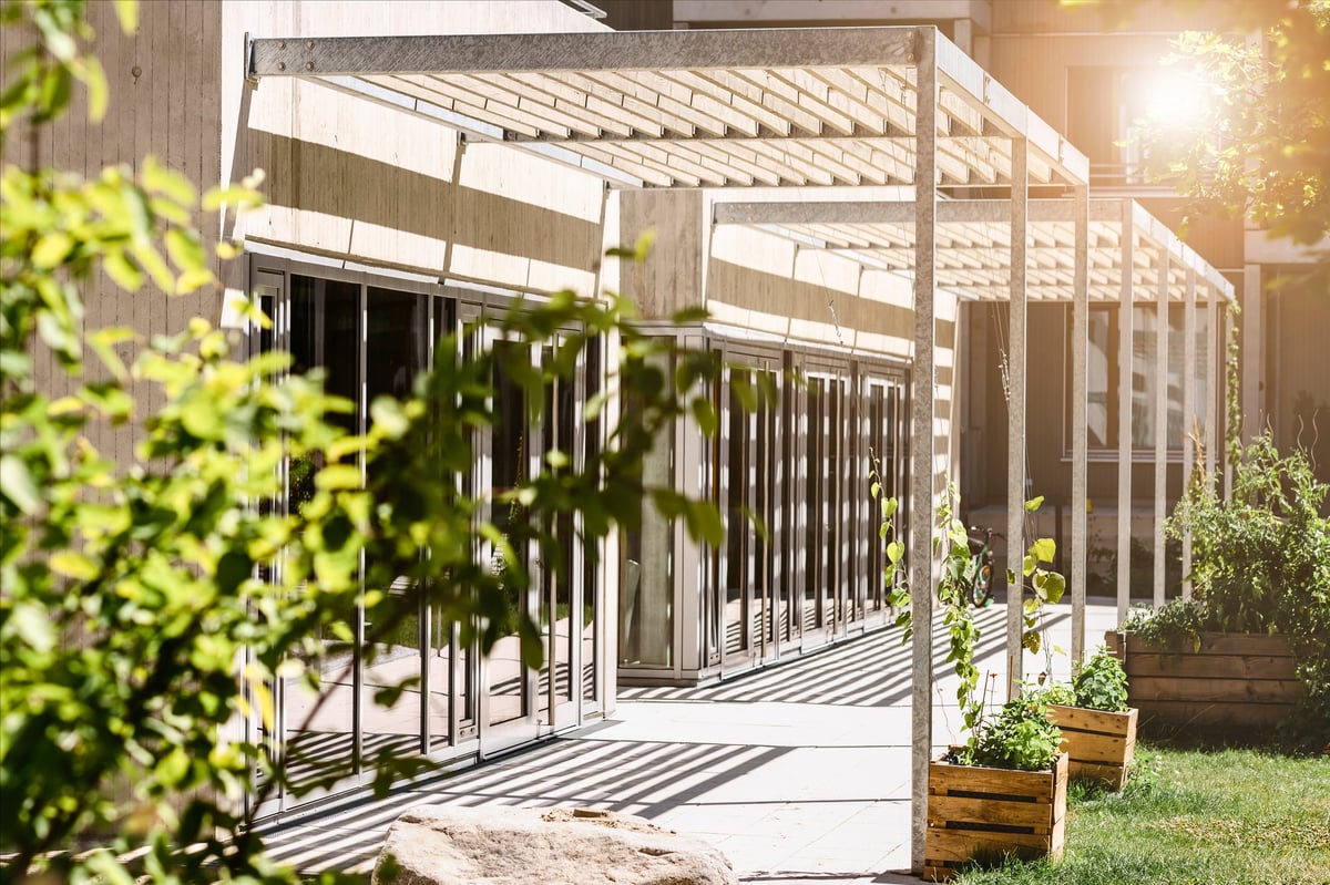 Pergola Awning attached to House Wall and Create Shadow. Trendy Modern Outdoor Patio Pergola with Landscaping.